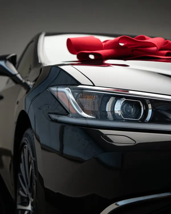 Czarny samochód z czerwoną kokardą na masce, grafika dla Lexus Ukleja